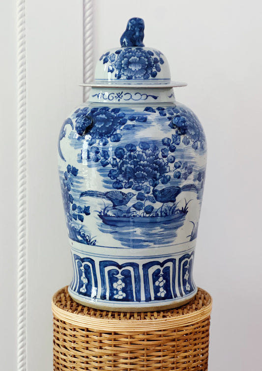 Large blue and white foo dog temple jar on a wicker pedestal