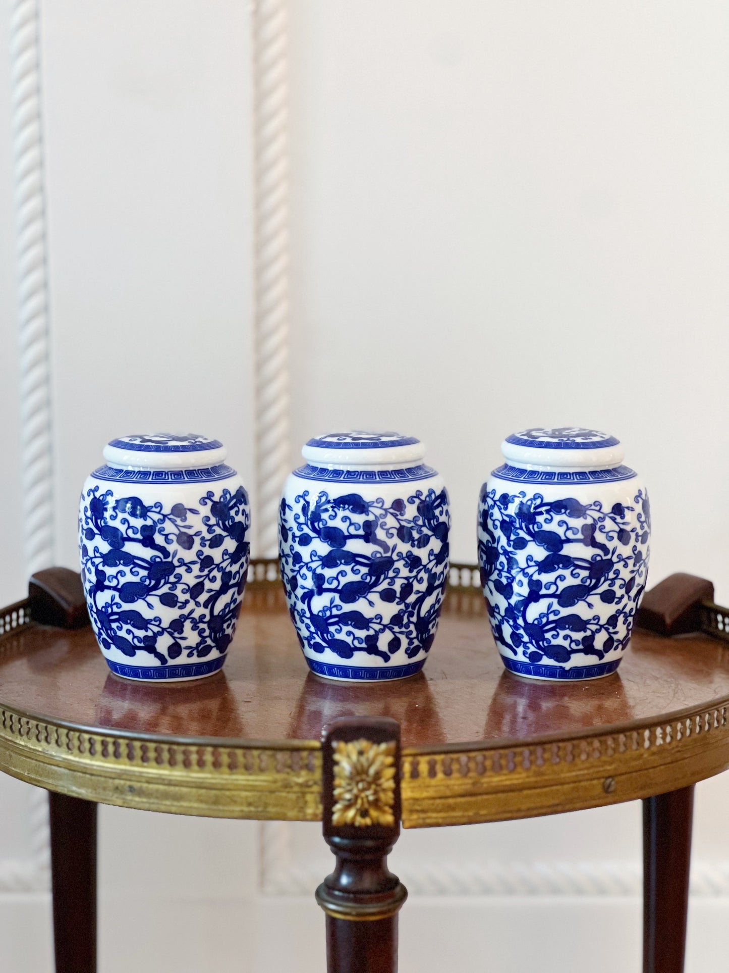 petite vintage blue and white ginger jars with lids on round wooden table