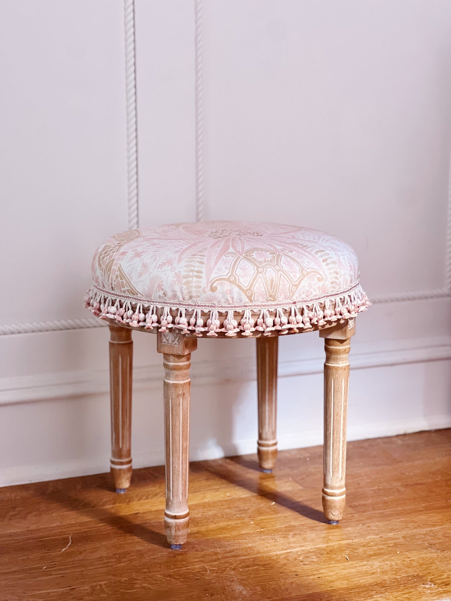 Vanity stool upholstered in custom fabric Schumacher cap Ferrat and scalamandre tassel trim 