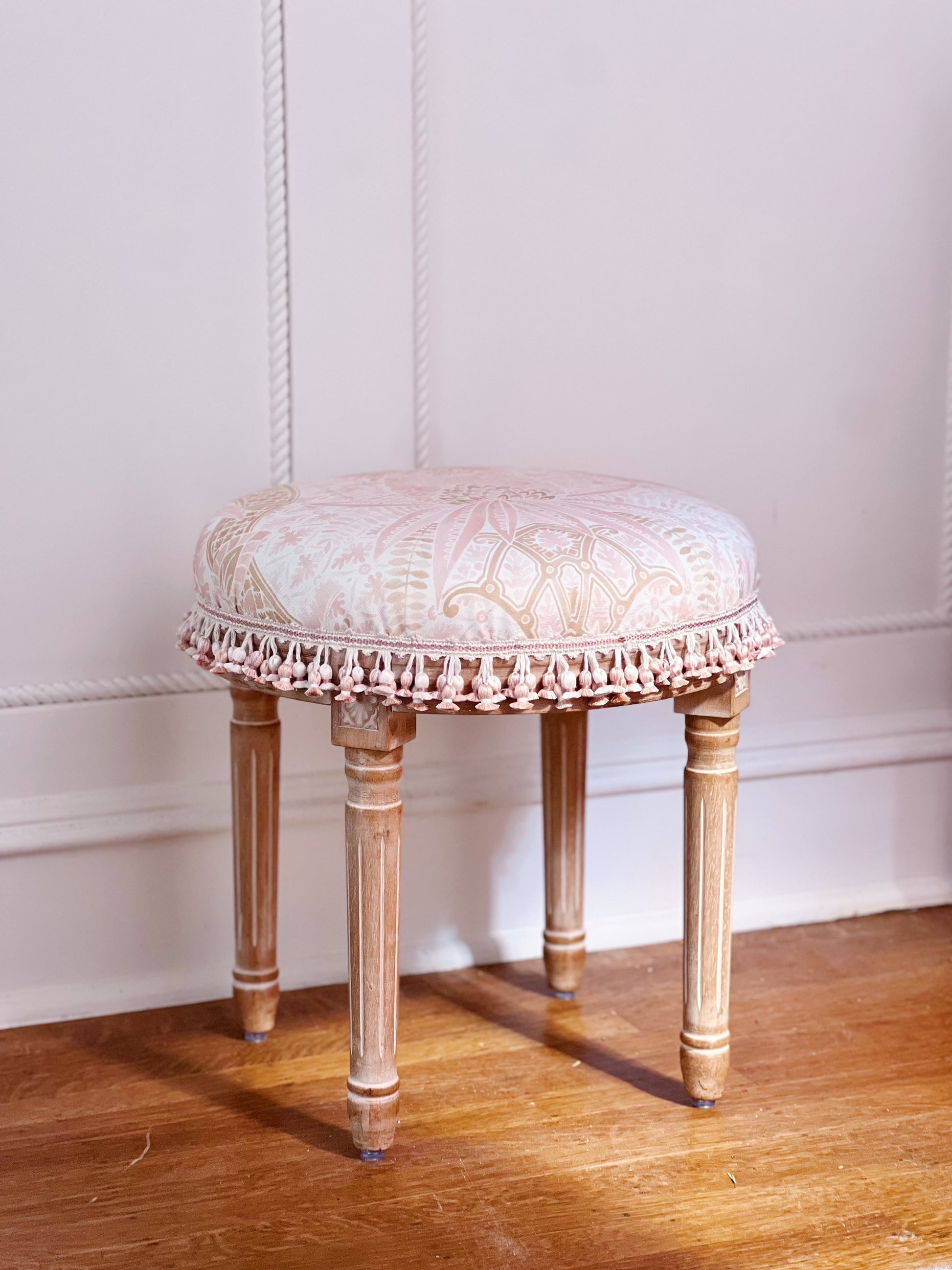 Vanity stool upholstered in custom fabric Schumacher cap Ferrat and scalamandre tassel trim 