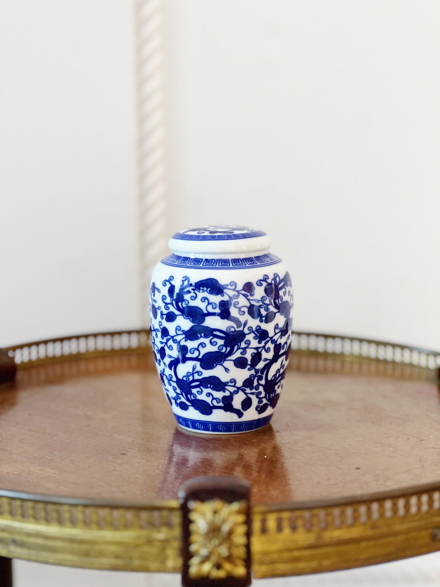 petite vintage blue and white ginger jar with lid on round wooden table