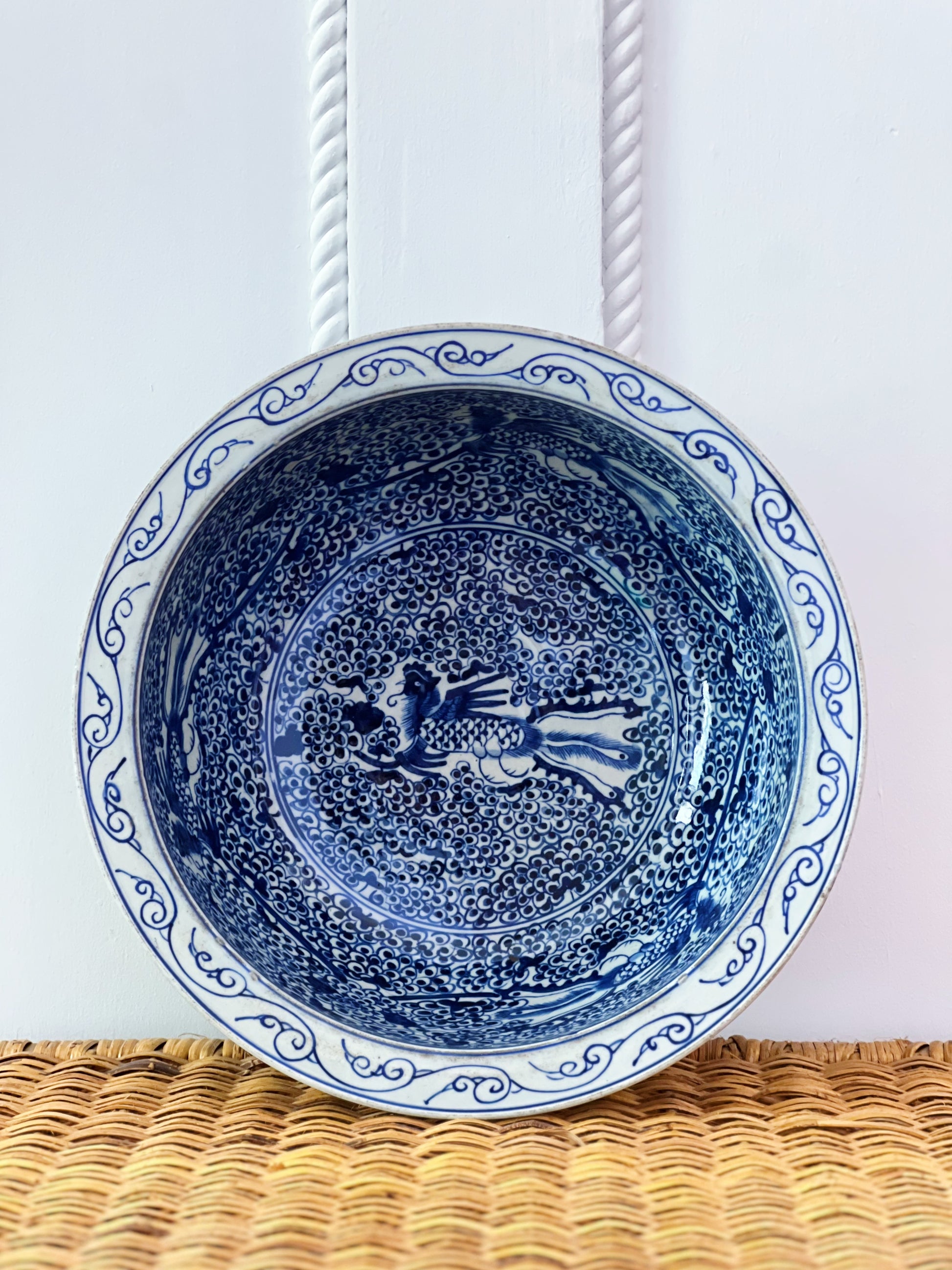 inside view of a blue and white basin bowl on a wicker shelf