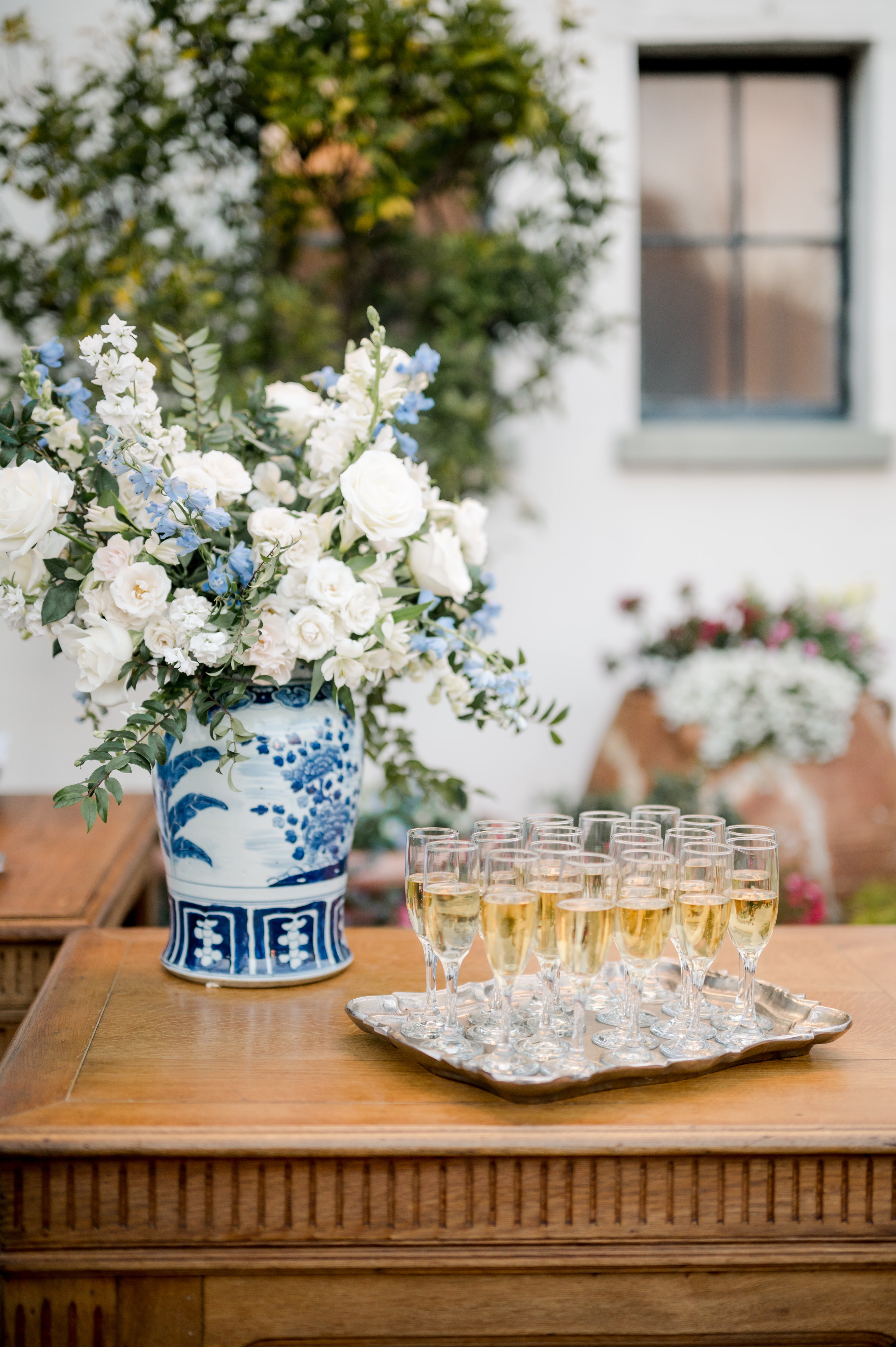 blue and white willow ware ginger jar vase with blue and white flowers and champagne in vintage Champagne flutes